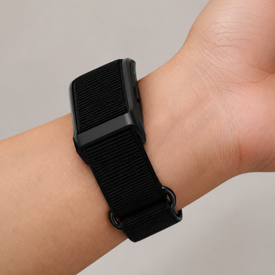 Bracelet RYTM en nylon tissé noir porté au poignet, boîtier du capteur visible sur le dessus.